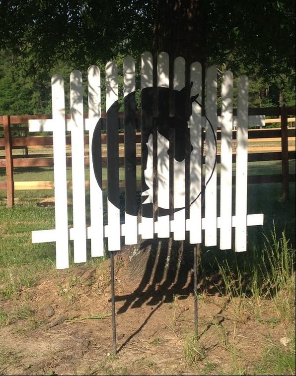 Image of the H.O.P.E. Acres horse logo on a sign resembling a white picket fence.